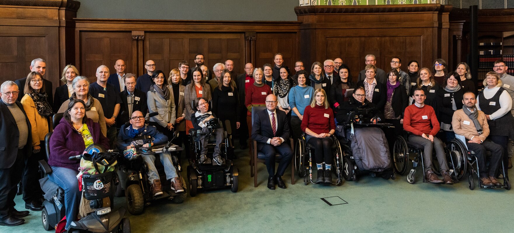 Gruppenbild der Mitglieder und Gäste im Halbkreis platziert